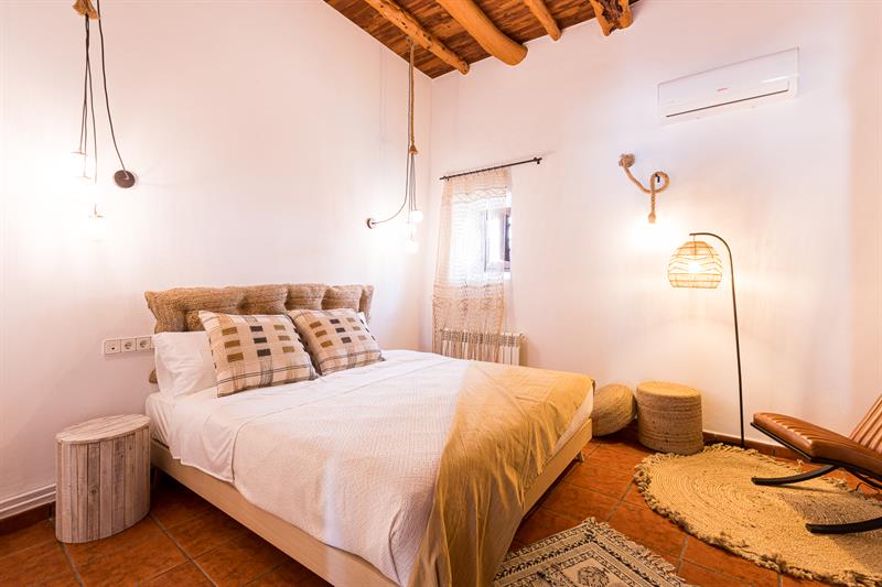 Bright bedroom with natural textiles and beamed ceiling