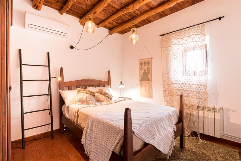 Bedroom with a wooden bed and a window onto the garden