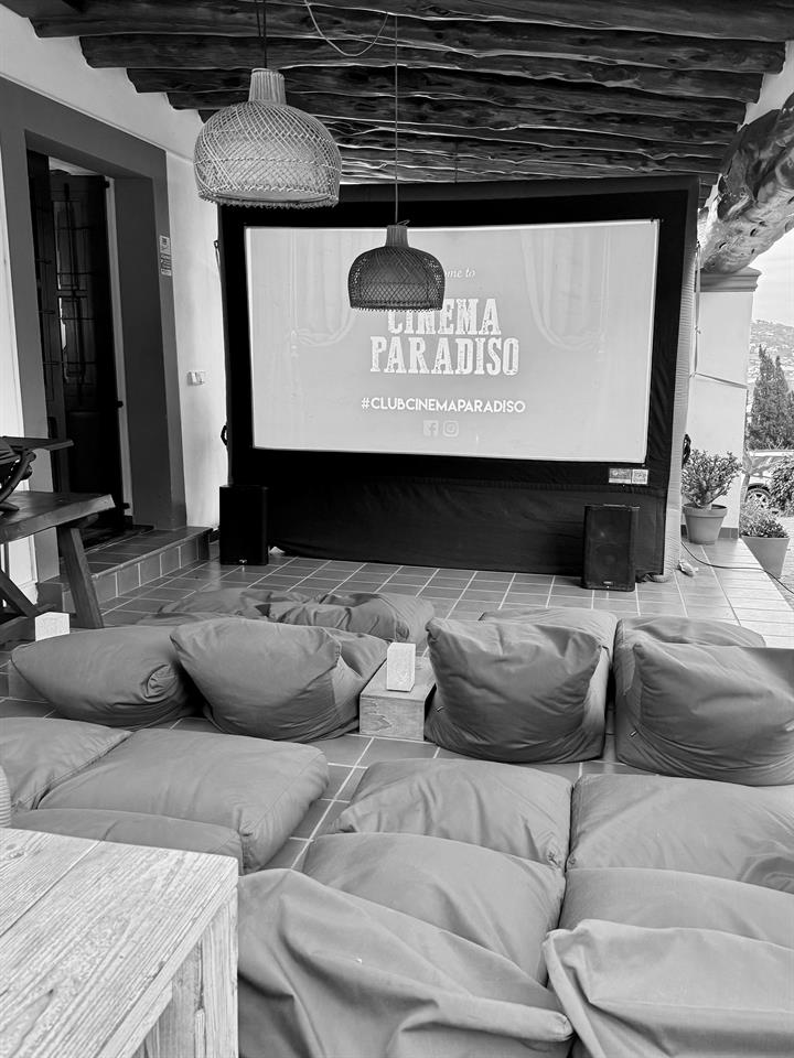 Movie night set up on the terrace with a big screen and floor cushions