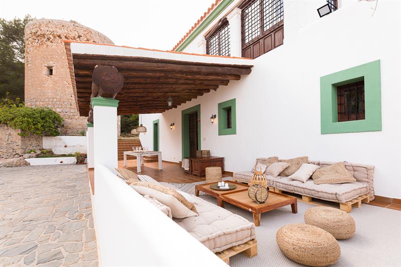 Lounge terrace with cushioned sofas beside the stone tower